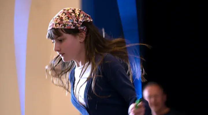 A girl jumps high as her skipping rope spins